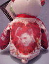 Back View of the Elvis 'Can't Help Falling In Love' Teddy Bear - (this is the 15th bear in the series) The Elvis Can't Help Falling In Love Bear has colorful images of Elvis. Both the front and the back of the bear are GREATLY detailed! The Bear wears a tag with information about the 'Can't Help Falling In Love': "The ballad, 'Can't Help Falling in Love,' is one of Elvis' classic hit songs. This single was featured in Elvis' 1961 film and album, Blue Hawaii. The lyrics were written by George David Weiss, Hugo E. Peretti, and Luigi Creatore. Originally performed by Elvis, numerous recording artists have also remade the song. 'Can't Help Falling in Love' continues to be one of the most romantic ballads of all time."