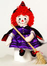 2003 Raggedy Ann Halloween Witch with Broom (14 1/2" broom) - special edition doll. Raggedy Ann has button eyes. Raggedy Ann wears a purple satin dress with glittering moons and stars, gold trim and a black suede cape with red liner and gold trim. She also wears a pointed hat with a red ribbon around it, red laced booties and holds a wooden broom with real straw.  16 inches