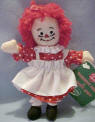 2003 Raggedy Ann Ornament / Package Decoration - Ann is wearing a red dress with white polka dots, white apron, white pantaloons, and red with white polka dot ribbon in her hair. 5 inches high