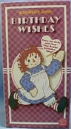 Happy Birthday Raggedy Ann Musical Plush Rag Doll - From the Raggedy Ann Collection. Raggedy Ann Happy Birthday Boxed Gift Doll. Raggedy Ann wears a&nbsp;multi&nbsp;color check dress with an apron&nbsp;that says "Happy birthday." Press her belly and hear "Happy Birthday To You." Comes in a gift box that opens at the front, with spaces to write in to/from. Measures 9" high.&nbsp; She is holding a plush gift in her hand. safe for ages over 3 