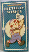 Happy Birthday Raggedy Andy Musical Plush Rag Doll - From the Raggedy Ann Collection. Raggedy Andy Happy Birthday Boxed Gift Doll. Raggedy Andy wears a&nbsp;multi&nbsp;color check shirt and coordinating blue bib overalls.&nbsp; Press his belly and hear "Happy Birthday To You." Comes in a gift box that opens at the front, with spaces to write in to/from. Measures 9" high.&nbsp; Andy is holding a plush gift. safe for ages over 3 