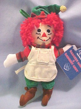 2002 Raggedy Andy Elf Ornament - Raggedy Ann wears a green corduroy top with plaid undershirt, red corduroy dress with white top apron, red corduroy hat and elf shoes. Raggedy Andy wears green corduroy pants, a red corduroy vest, plaid undershirt, green corduroy elf hat, apron with pockets and elf shoes. Each has a fabric loop on the back to hang it with. He has embroidered eyes and facial features. 6 inches high