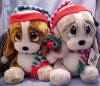 Christmas Musical Plush Sad Sam and Honey Basset Hound Carolers in Hats - Play 'Silent Night' and 'We Wish You a Merry Christmas' when their feet are pushed.  Sam is wearing a red, green, and blue gray stocking cap and matching neck scarf.  Honey is wearing a red and blue gray stocking cap and matching neck scarf.  She has evergreen color velvety bows on her ears. 13 inches high each