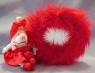 Front view of the Gund Olivia Pig Dresser Mirror - Olivia is holding a tube of lipstick in her hand with lipstick on her lips. She has a red satiny bow around her ears which matches her red satiny evening dress with white pearly looking necklace and bracelet on. On Olivia's feet are red satiny dress shoes. She is fully dressed for an evening out on the town! The mirror is actually bigger than it appears in the picture.  Surrounding the mirror is fluffy red feather material.Olivia Pig can be removed from the base with a snip of the threads. Her dress is also removable.  9 inch base 7 inch mirror with an 8inch Olivia