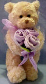 Gund Teddy Bear with Lilac Flower Bouquet  The Teddy Bear is made from a ultra soft plush material. The flowers are velvety soft and arranged with netting and matching bow.  11 inches