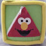 Gund Sesame Street Activity Block (click on the picture for a larger view)  Side 1 is Elmo - Unzip the zipper triangle to see a triangle MIRROR and the word 'triangle'.  Side 2 is Ernie with his Rubber Duckie (Duckie krinkles when you squeeze it) - Unvelcro the oval flap to find a leathery feeling oval shape&nbsp;and the word 'oval'.  Side 3 is Big Bird - Unbotton the buttoned triangle&nbsp;to find a laced platellet&nbsp;to learn how to tie your shoes and the word 'rectangle'.  Side 4 is Cookie Monster - Unvelcro the blue circle to find a cookie that krinkles and the word 'circle'.  Side 5 is Zoe - Unvelcro the orange square to find 2 square plastic toys and the word 'square'  Side 6 is a shiny Sesame Street star - Unvelcro the star to find the numbers 1, 2, 3, 4, and 5 and the word 'star'.  7 1/2 inch cube