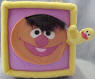 Gund Sesame Street Activity Block (click on the picture for a larger view)  Side 1 is Elmo - Unzip the zipper triangle to see a triangle MIRROR and the word 'triangle'.  Side 2 is Ernie with his Rubber Duckie (Duckie krinkles when you squeeze it) - Unvelcro the oval flap to find a leathery feeling oval shape&nbsp;and the word 'oval'.  Side 3 is Big Bird - Unbotton the buttoned triangle&nbsp;to find a laced platellet&nbsp;to learn how to tie your shoes and the word 'rectangle'.  Side 4 is Cookie Monster - Unvelcro the blue circle to find a cookie that krinkles and the word 'circle'.  Side 5 is Zoe - Unvelcro the orange square to find 2 square plastic toys and the word 'square'  Side 6 is a shiny Sesame Street star - Unvelcro the star to find the numbers 1, 2, 3, 4, and 5 and the word 'star'.  7 1/2 inch cube