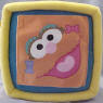 Gund Sesame Street Activity Block (click on the picture for a larger view)  Side 1 is Elmo - Unzip the zipper triangle to see a triangle MIRROR and the word 'triangle'.  Side 2 is Ernie with his Rubber Duckie (Duckie krinkles when you squeeze it) - Unvelcro the oval flap to find a leathery feeling oval shape&nbsp;and the word 'oval'.  Side 3 is Big Bird - Unbotton the buttoned triangle&nbsp;to find a laced platellet&nbsp;to learn how to tie your shoes and the word 'rectangle'.  Side 4 is Cookie Monster - Unvelcro the blue circle to find a cookie that krinkles and the word 'circle'.  Side 5 is Zoe - Unvelcro the orange square to find 2 square plastic toys and the word 'square'  Side 6 is a shiny Sesame Street star - Unvelcro the star to find the numbers 1, 2, 3, 4, and 5 and the word 'star'.  7 1/2 inch cube