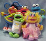 Gund Sesame Street Set of 5  Zoe, Oscar the Grouch, Elmo, Ernie and Cookie Monster Plush Treasure Keeper Backpack Clip Ons. Each Treasure Keeper has a Backpack on his or her back.  The backpack velcros open and shut to be able to put small trinkets or money in.  (the backpack can be removed with a snip of a few threads. Except for Oscar he does not have a backpack) Each of the Clips is 2 1/2". 