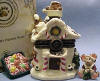 Front view of 1st Edition Boyds Uncle Beans Treasure Box Kringles Sweet Retreat with S. C. McNibble -(Introduced Fall 2002 and has been retired.) Inspired by Boyds' QVC exclusive Kringle's Village piece! This candy-coated Treasure Box is designed in the shape of a gingerbread house with all the trimmins. Pop the sparkly rooftop to find a lift out tray filled with hard candies. S.C. McNibble hides underneath, protectin' his stash of Christmas candies! Quote on bottom: "How sweet it is!" - Jackie Gleason 2 1/4 inches high by 1 3/4 inches wide