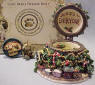 Open view of Boyds Uncle Beans Treasure Box Kringles Christmas Tree - (Introduced in Fall 2003 and has been retired) This magnificent Christmas tree treasure box-decked with baubles, beads, candy canes, a star topper, and a choo choo train around the base--opens to reveal a special holiday message on the inside lid; a cookie and milk tray for Santa; and, underneath, Frazier, an elf mouse wrapped up in colored lights. Quote: "Merry Christmas to all and to all a good night!"