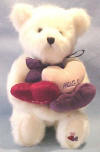Boyds Oliver Bearlove White Teddy Bear - (introduced in Fall 2002 and has been retired)   This BEAUTIFUL Shiny White Bear has jointed arms, legs, and head.  It has a purple silky ribbon tied in a bow around its neck.  it haw 3 hearts embroidered on the bottom of its left foot.  It is holding 3 velvety hearts Lilac ones says 'Hugs', Red one says 'Kisses', and Purple ones says 'Be Mine'.  It has beautiful green eyes and an embroidered black nose.&nbsp; (safe for ages over 3)  13 inches and poseable