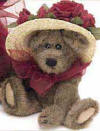 Boyds Ginnie Higgenthorpe Teddy Bear - (introduced Spring 2000 and has been retired)  In keeping with family Traditions, Ginnie Higgenthorpe is eager to learn propah Hattery from her Auntie Lavonne. Who better to teach her the fine Art of Caps...with all the Blooms, Buttons and Bows to accessorize them Just Right!  Ginnie is wearing a large hat with burgundy flowers.  Around her neck is a large burgundy bow that helps hold her little hat on.  6 inches and poseable