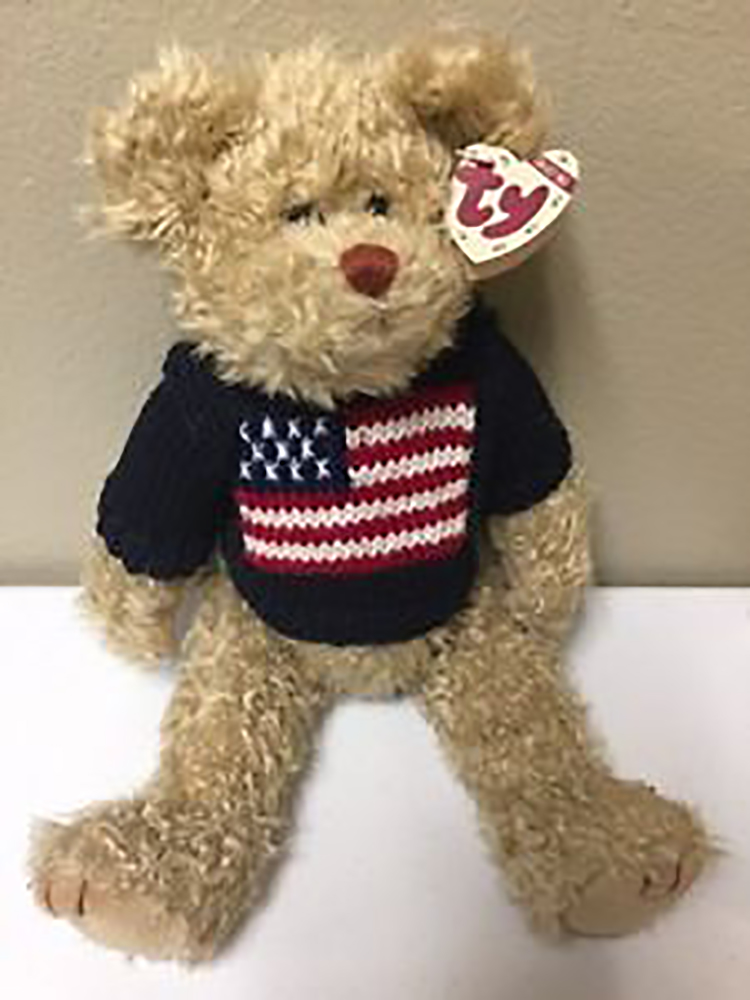 TY Attic Treasure Grant Patriotic Teddy Bear TY Attic Treasure Grant Patriotic Teddy Bear
- introduced on 1/1/98 and retired on 8/30/99
- Fully jointed plush tan teddy bear
- He is wearing a dark blue sweater with an American flag on the front
- Designed by Ty Warner